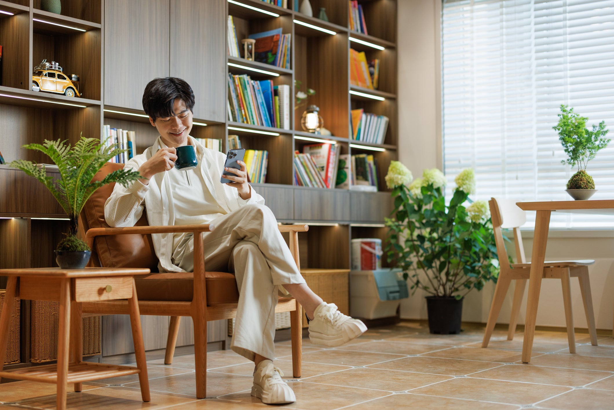 Person relaxing indoors with coffee and phone